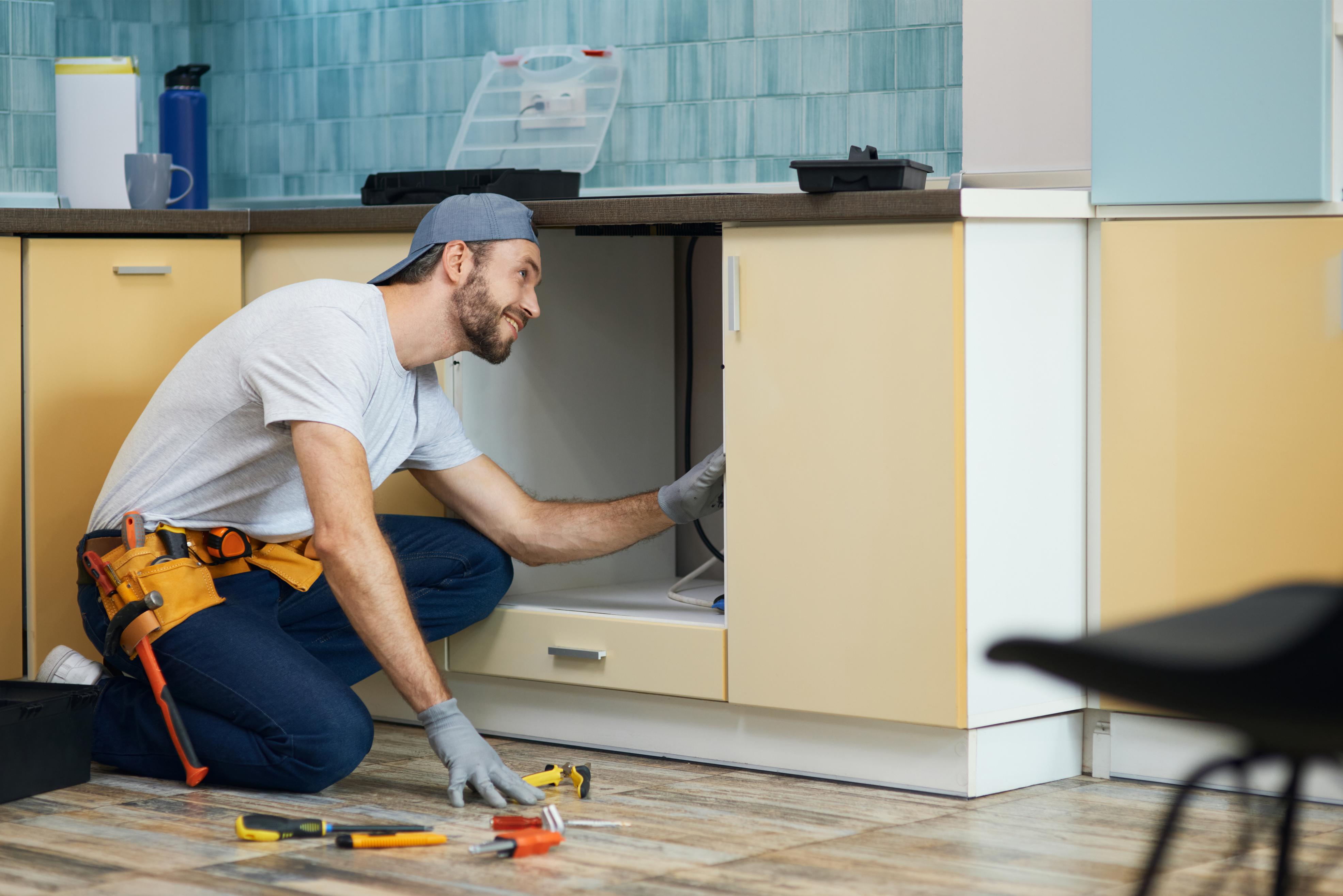 Plumber repairing a kitchen sink in Spring Lake, NC